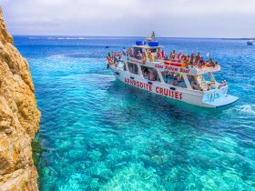A lively group enjoys a glass bottom boat cruise in crystal-clear waters, perfect for exploring marine life and enjoying a day on the ocean.