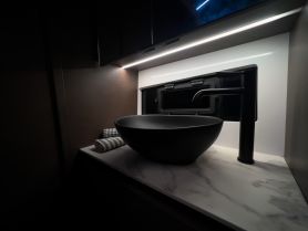 A sleek and modern bathroom interior featuring a stylish black sink and marble countertop, perfect for luxury boating experiences.