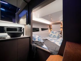 A cozy and modern boat cabin featuring a comfortable bed and stylish amenities, perfect for relaxing during your nautical adventures.