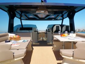 The interior of a luxurious boat featuring comfortable seating and a dining area, perfect for enjoying meals while cruising on the water.