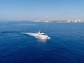 A stunning aerial view of a yacht cruising through calm blue waters, showcasing the beauty of maritime adventures.
