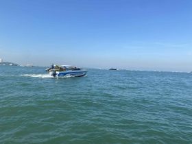 A speedboat named 'Prasitporn' glides through clear waters, showcasing the beauty of a day on the sea.