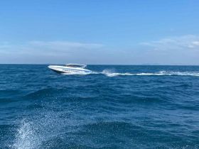 A sleek speedboat glides through the vibrant blue waters, showcasing the thrill of boating adventures on the open sea.