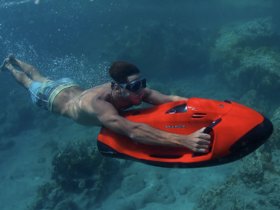 A diver enjoys an exhilarating underwater experience while using a sea scooter, showcasing the thrill of snorkeling and diving adventures.