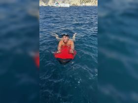 A woman enjoys snorkeling in crystal-clear waters, showcasing the excitement of water activities during a boat trip.