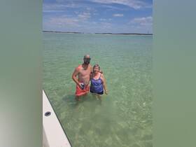 A couple enjoys a refreshing swim in clear waters, capturing a perfect moment of relaxation and fun under the sun.