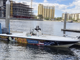 A sleek speedboat docked at the marina, showcasing its vibrant design and fishing equipment, perfect for adventurous outings on the water.