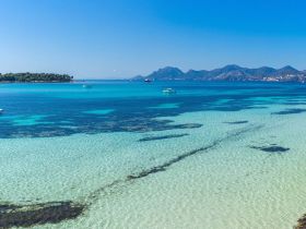 A stunning view of turquoise waters and a picturesque coastline, showcasing the beauty of a serene island destination — perfect for boating adventures and relaxation.