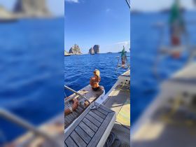 A woman enjoys the stunning view of rocky islands from the deck of a boat, capturing the essence of a perfect day on the water.