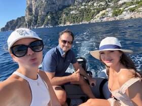A cheerful group enjoys a boat ride near the stunning coastline of Capri, capturing the essence of adventure and relaxation on the water.