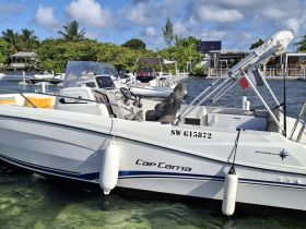 A sleek speedboat named 'Cap Cama' docked in clear waters, showcasing its modern design and inviting atmosphere for a day on the water.