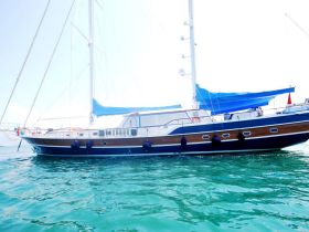A stunning side view of a yacht gliding through clear turquoise waters, showcasing its elegant design and perfect for luxury sailing experiences.
