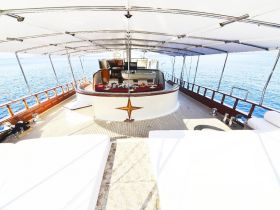 An elegant interior view of a yacht's helm area, showcasing luxurious seating and a well-appointed cabin, perfect for relaxing while cruising on the open water.