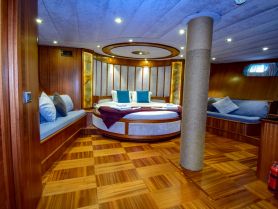 A beautifully designed cabin interior featuring comfortable seating and elegant decor, perfect for relaxation on a luxury yacht.