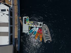 An aerial view showcasing a variety of water toys including paddleboards, kayaks, and a jet ski, all ready for fun on the water.