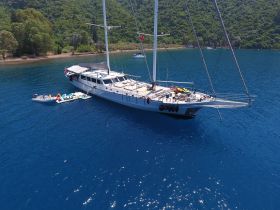 A stunning aerial view of a luxurious yacht anchored in crystal-clear waters, showcasing its elegant design and surrounding natural beauty.
