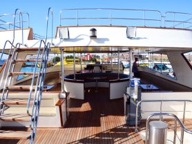 A spacious interior view of a yacht's cabin featuring comfortable seating and a helm area, perfect for relaxing and enjoying the journey on the water.