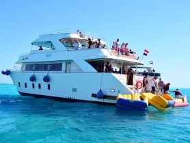 A lively group enjoys water activities aboard the Sirena 2, with guests preparing to have fun on inflatable floats in the clear blue waters.