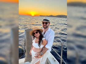 A couple enjoys a romantic sunset on a yacht, celebrating a special moment with the beautiful ocean backdrop — perfect for memorable occasions.