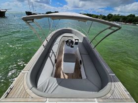 Interior view of a spacious boat helm and seating area, showcasing comfortable seating and a well-equipped console, perfect for a day on the water.