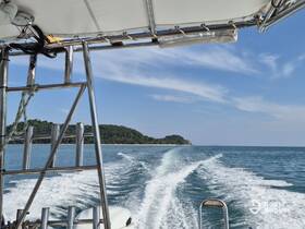 A scenic view from the boat, showcasing the wake and a distant island under a clear blue sky — perfect for exploring coastal destinations.