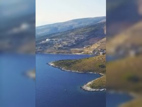 A stunning aerial view of a serene coastline, showcasing the natural beauty of the landscape and the tranquil waters — perfect for exploring by boat.