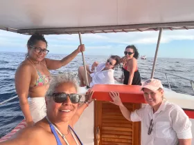 A joyful group of friends poses for a selfie on a boat, enjoying their time on the water — perfect for memorable outings and celebrations.