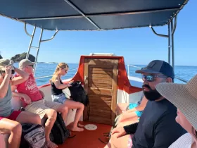 Guests relax inside a boat, enjoying the scenic views while seated comfortably. This interior shot captures the essence of a leisurely boat ride.