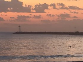 A hazy view of a pier at sunset, with indistinct details and a soft color palette, creating an atmospheric but unclear scene.