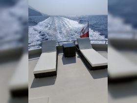 A serene view of lounge seating on a boat's deck, perfect for relaxing while cruising through beautiful waters.