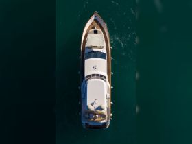 Aerial view of a sleek yacht showcasing its elegant design and spacious deck, perfect for luxury cruising on the open water.