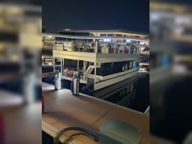 A beautifully lit boat docked at night, showcasing its sleek design and surroundings — perfect for evening cruises or events.