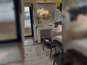 A beautifully decorated interior of a boat for a birthday celebration, featuring flowers, balloons, and a 'Happy Birthday' sign, creating a festive atmosphere.