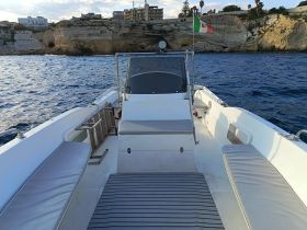 A spacious interior view of a boat featuring comfortable seating and a helm, perfect for enjoying a day on the water.