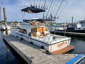 A fishing boat named 'Lucy B' docked at the marina, showcasing its spacious deck and fishing gear — perfect for a day out on the water.