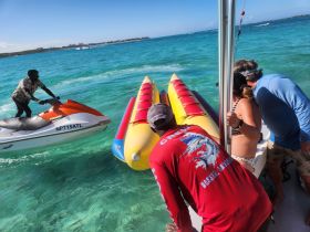 Guests prepare for an exciting day on the water, with a jet ski and banana boat ready for adventure in the beautiful turquoise sea.