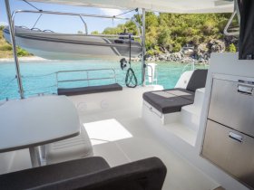 Interior view of a spacious boat cabin featuring comfortable seating and a dining area, perfect for relaxing while enjoying the beautiful surroundings.