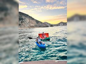 A group enjoys a fun kayaking experience at sunset, surrounded by stunning coastal scenery — perfect for adventure seekers and beach lovers.