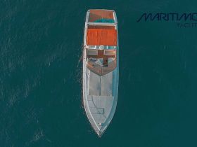 A stunning aerial view of a yacht cruising through deep blue waters, showcasing its elegant design and spacious deck — perfect for luxury charters and unforgettable experiences on the water.