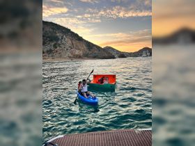 A family enjoys a sunset kayaking adventure, with laughter and smiles as they paddle through beautiful waters — perfect for creating lasting memories on the water.