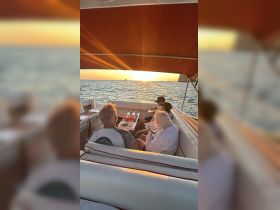 A group enjoys a sunset dining experience on a boat, creating the perfect atmosphere for celebrations and memorable moments on the water.