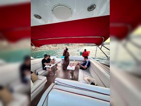 A group of friends relaxes on the interior of a boat, enjoying drinks and the scenic view — perfect for a day of leisure on the water.