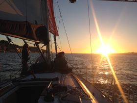 A group enjoys a picturesque sunset while sailing, creating a perfect backdrop for memorable moments on the water.