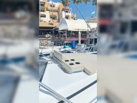 A close-up view of the seating area on a boat, featuring cup holders and a cooler, perfect for enjoying refreshments while on the water.