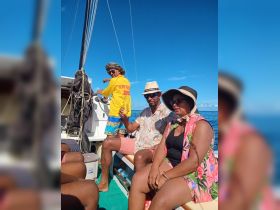 A lively group enjoys their time on a boat, with drinks in hand and smiles all around, perfect for a fun day on the water.
