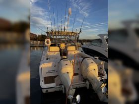 A detailed view of a fishing boat named 'Geronimo' docked in Washington, DC, showcasing its outboard motors and fishing gear, perfect for anglers seeking adventure on the water.