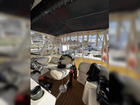 Interior view of a boat's helm area, showcasing comfortable seating and storage, perfect for a day on the water.