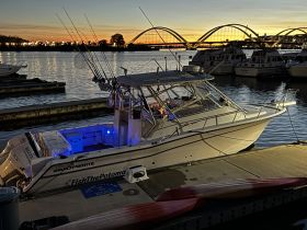 A Grady White fishing boat docked at sunset, showcasing its sleek design and fishing gear, perfect for charters on the Potomac River.