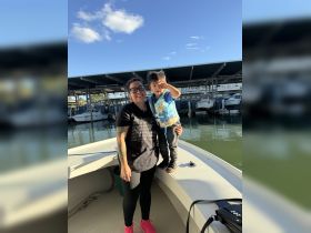 A joyful moment captured with a woman and a child aboard a boat, showcasing family fun on the water.