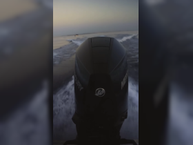 An unclear view of a boat's motor cutting through the water, capturing the essence of speed on the open sea.